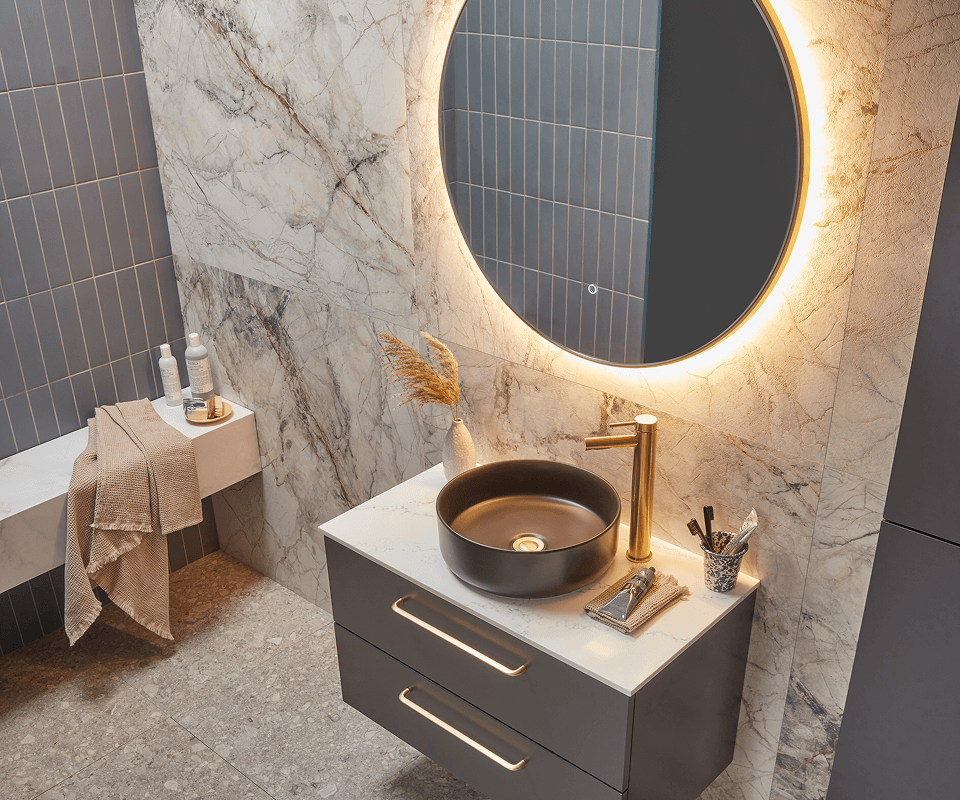 a modern bathroom featuring a sleek counter and a round mirror above it