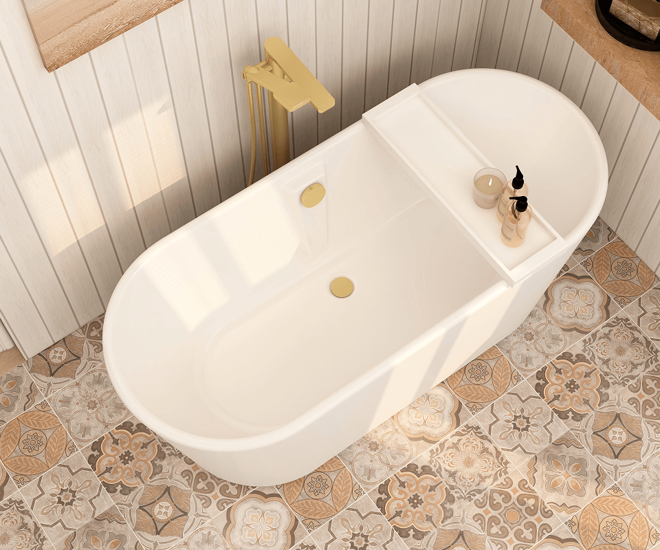 a top down view of a white bathtub with gold fixtures on a patterned tile floor