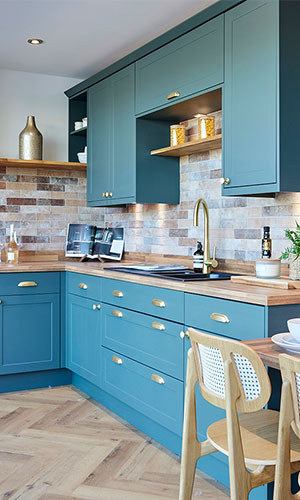 blue cupboards and draws with warm lighting with brick designed walls
