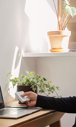 person using remote controll device to activate rain sensor which will close windows automatically when it detects rain