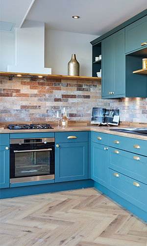 blue cupboards and draws with warm lighting with brick designed walls