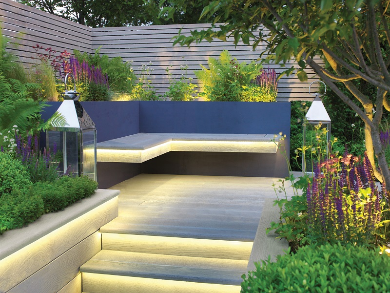 Outdoor steaing area with steps with warm lighting to outdoor sofa which also has warm lighting installed