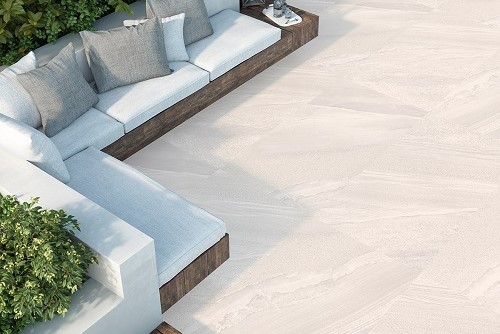 Outdoor corner sofa with wooden base and white cushions