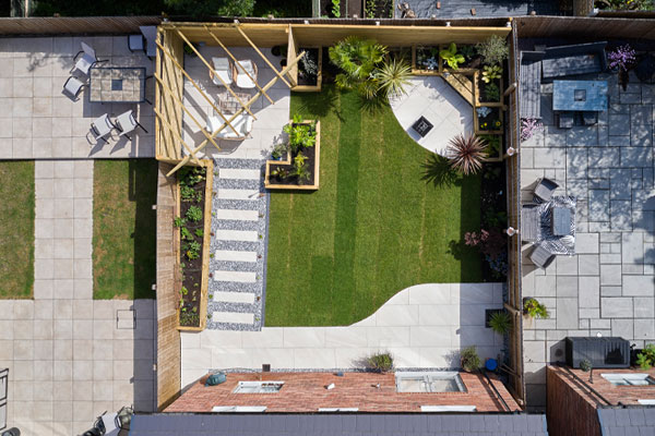 Birds eye view of garden with with stone path with stepping slabs stripped grass and seating area