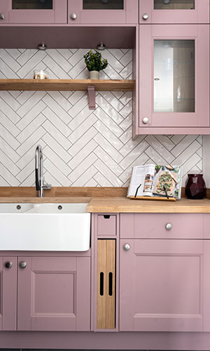 Pink wooden cabinates with built in white sink and shelves