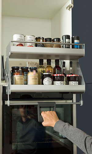 man holding handle to pullout shelf containing ingredients