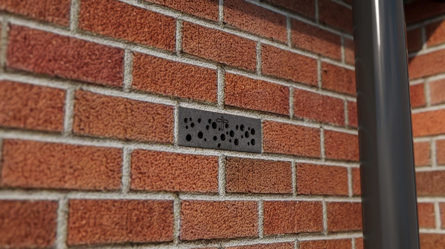 black brick in the wall with holes for bees to build a hive inside