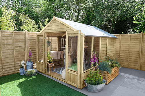 summer house with open doors surrounded by plaqnts, containing small seating area with cushions