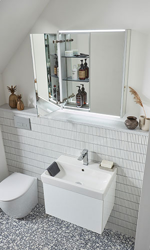 high view of bathroom with white sink attached to wall, mirror cabinet which opens from the middle