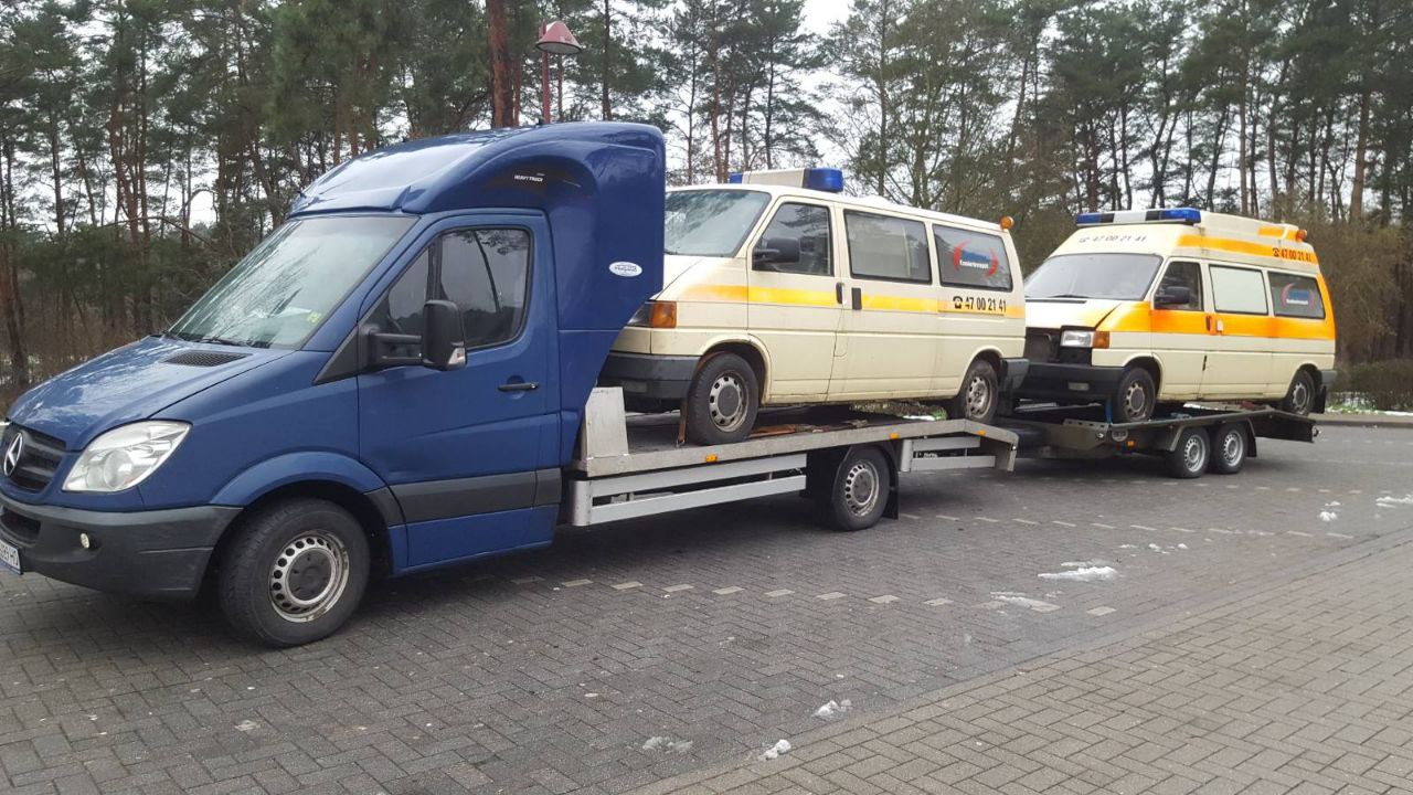 flat bed truck carrying 2 ambulances