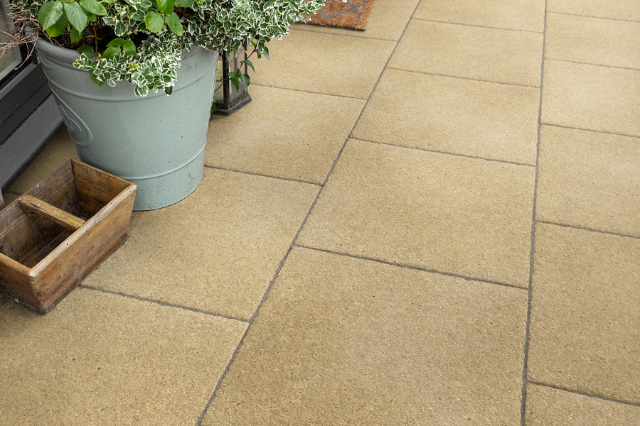 Yellow concrete paving with plant pots containing shrubs