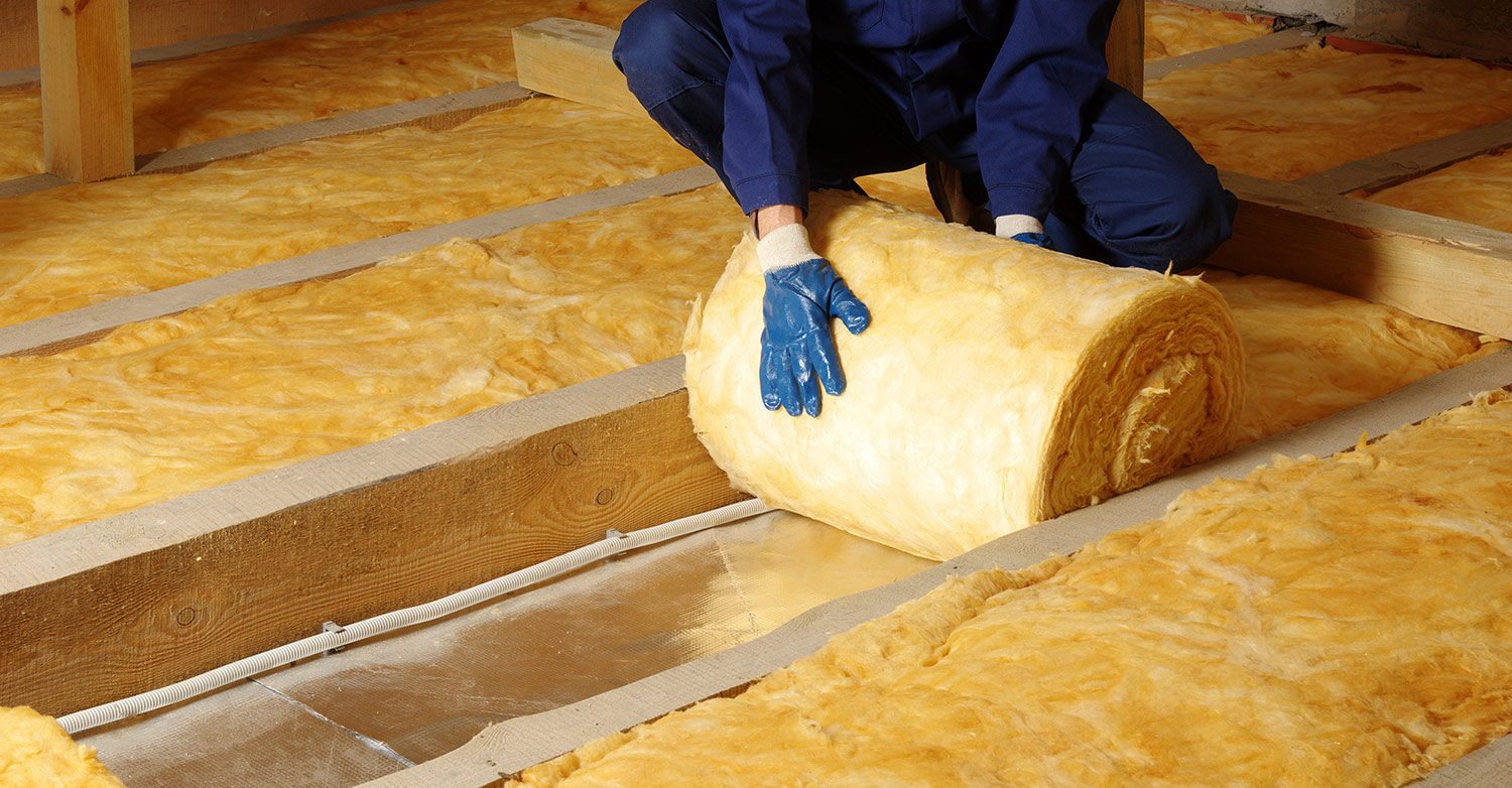 construction worker installing heat insulation to building