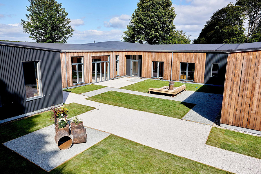 Outside view of self-build project with wooden walls gravel paving and exterior details